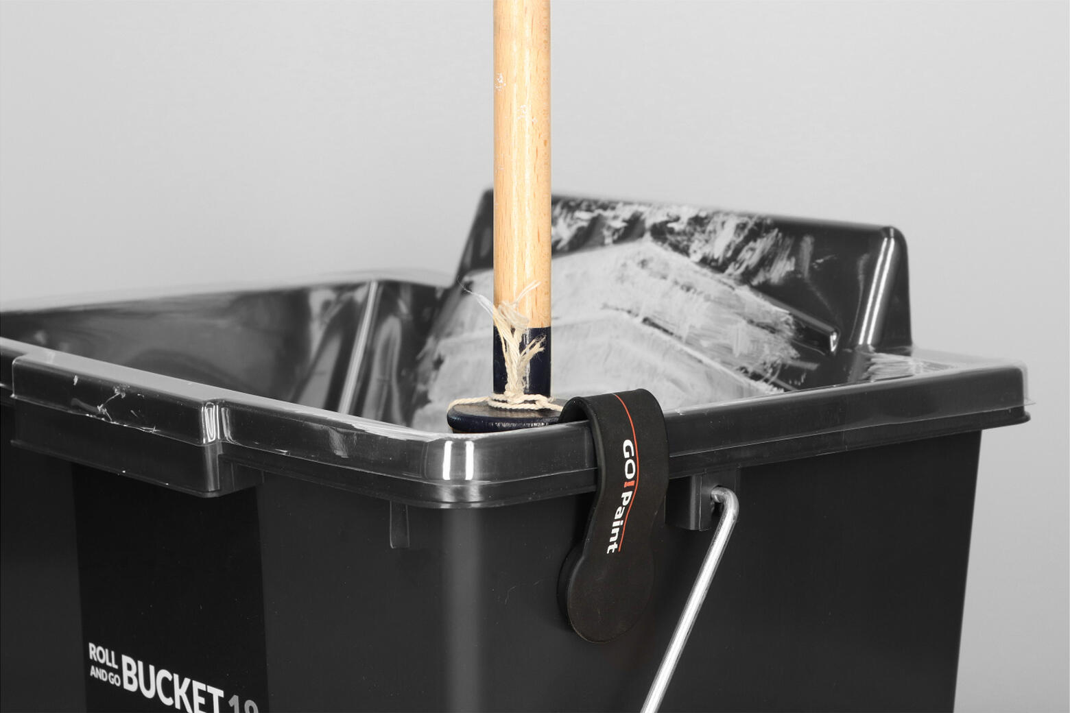 Fold the clip over the edge of a bucket and hang the brush on the side